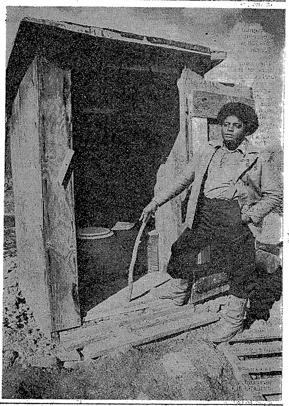 Community center employee Sonny Metcalf stands in front of LLV outhouse in 1980