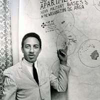 Photograph of ACCESS Chairman Charles Jones in front of a poster in 1967.