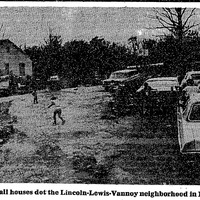 Small homes and broken cars line LLV dirt road